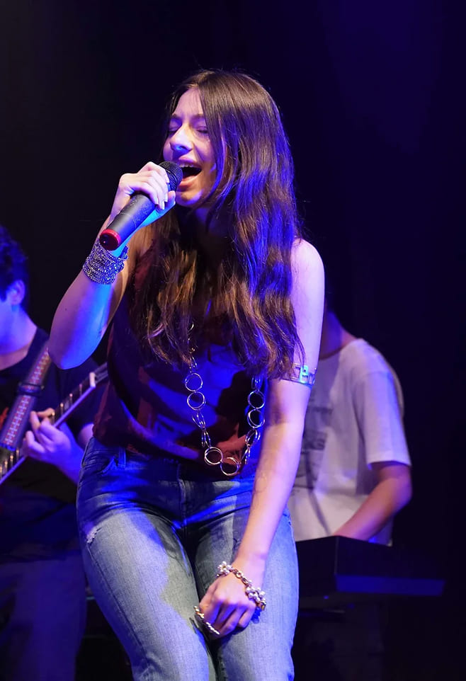 Studentessa della Scuola di Musica Cluster canta dal vivo durante una performance con band