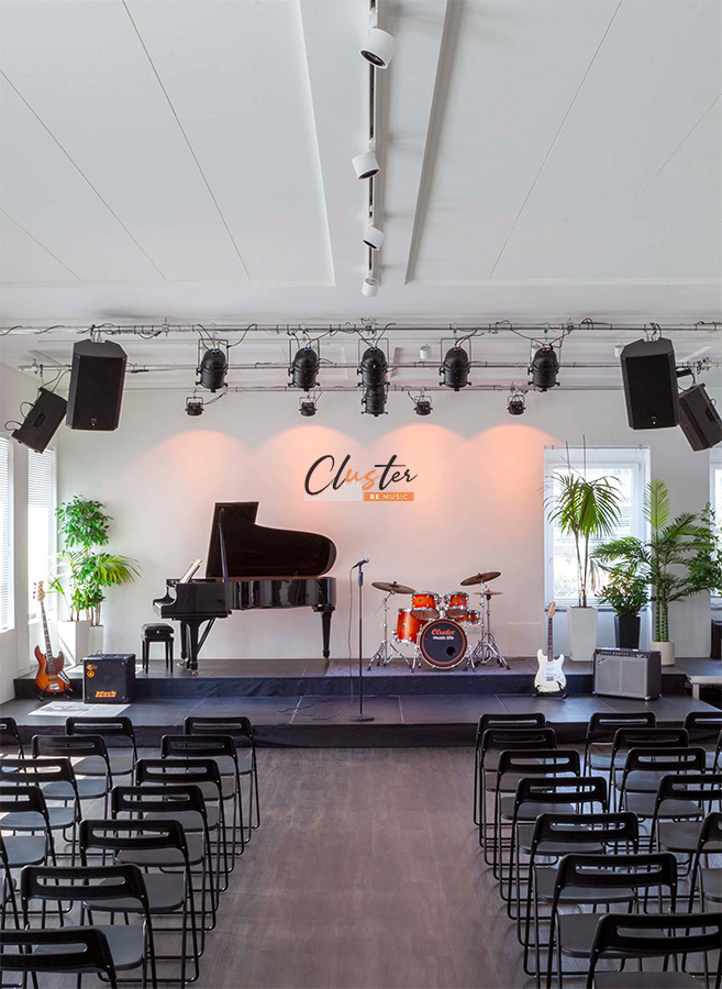 Auditorium della Scuola di Musica Cluster con pianoforte, batteria e sedie allestite per l’Open Day