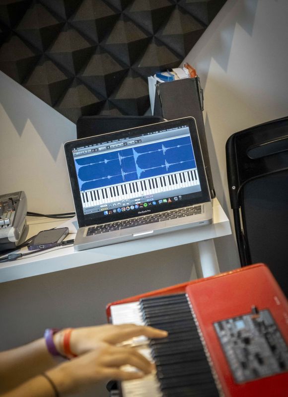 Band di studenti della Scuola di Musica Cluster in concerto con batteria, basso e chitarra sul palco.